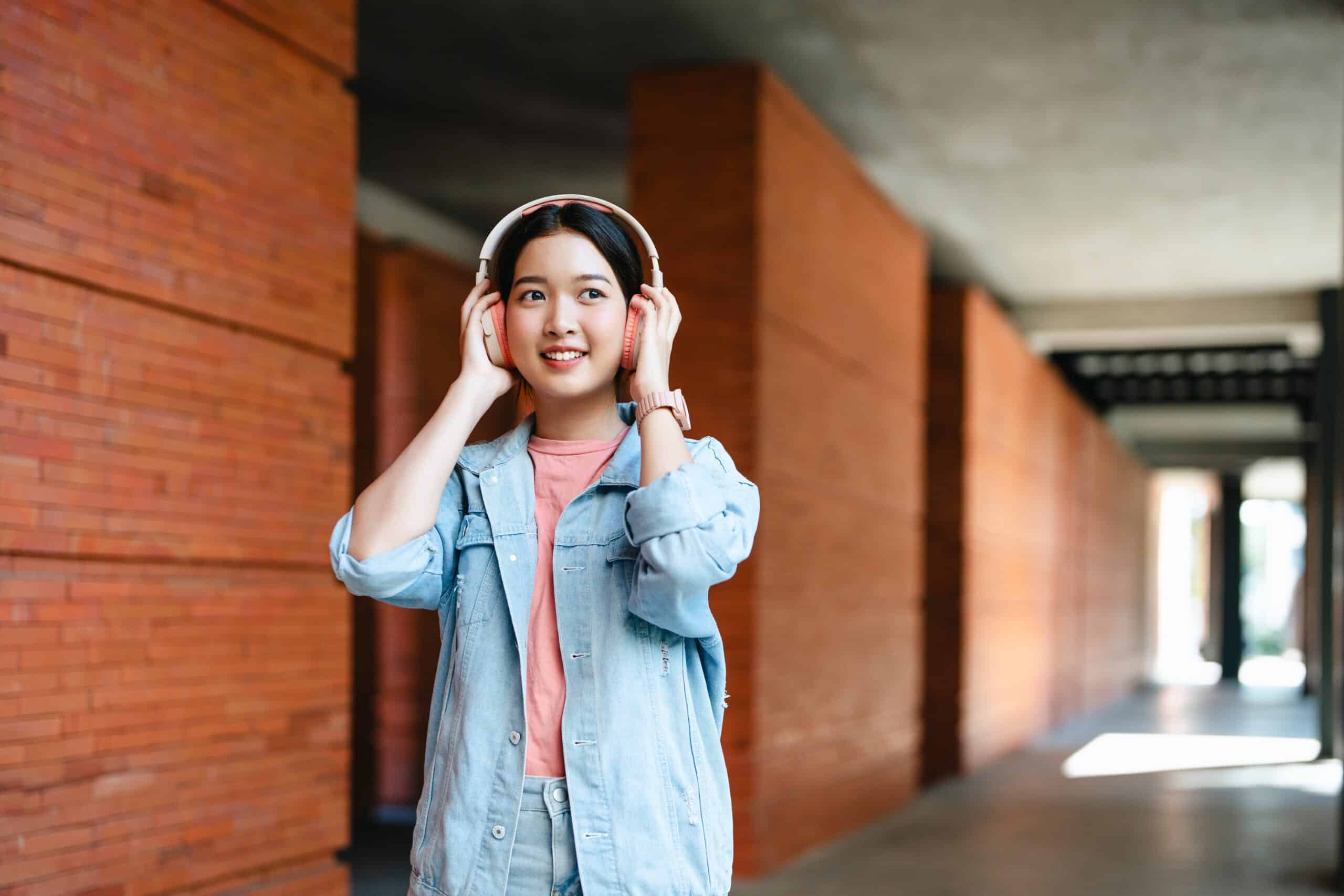 Cheerful,Young,Woman,In,Casual,Shirt,,Wearing,Earphones,,Standing,Listening Cheerful,Young,Woman,In,Casual,Shirt,,Wearing,Earphones,,Standing,Listening